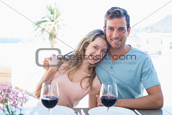 Loving couple with wine glasses at dining table