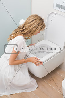 Woman about to vomit into a toilet