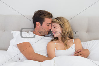 Relaxed young couple sitting in bed