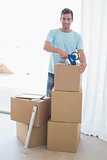 Young man with cardboard boxes in new house