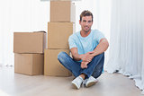 Young man with cardboard boxes in new house