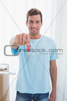 Young man holding out new house key