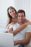 Relaxed couple using laptop on couch