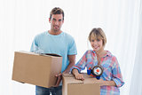 Happy young couple with cardboard boxes