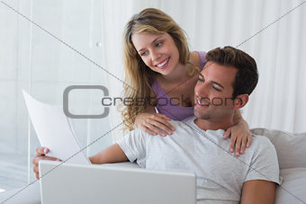 Relaxed couple using laptop on couch