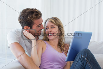 Happy young couple using digital tablet together