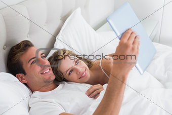 Relaxed couple using digital tablet on couch