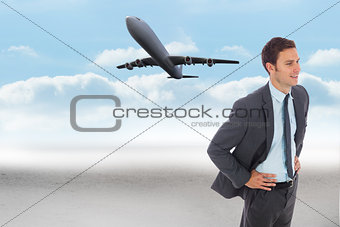 Composite image of cheerful businessman standing with hand on hip