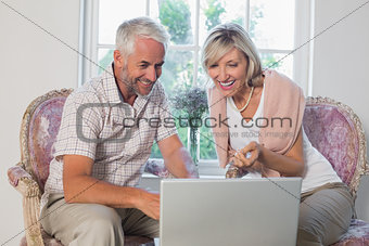 Couple discussing while using laptop at home