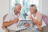 Couple reading newspaper while drinking coffee