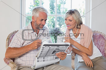 Couple reading newspaper while drinking coffee