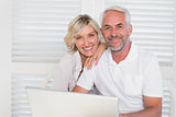 Portrait of mature couple using laptop at home