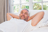 Relaxed mature man lying in bed at home