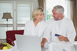 Happy mature couple doing online shopping at home