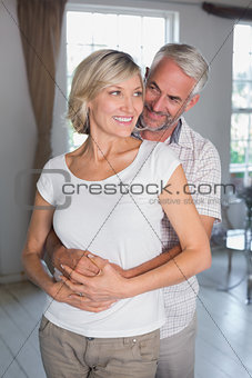 Mature man embracing woman at home