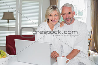 Relaxed mature couple with laptop at home