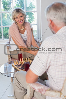 Mature couple playing chess at home