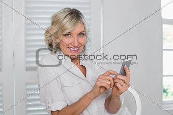 Relaxed mature woman text messaging at home