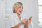 Cheerful mature woman text messaging
