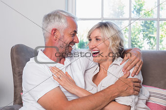 Cheerful mature couple sitting on couch