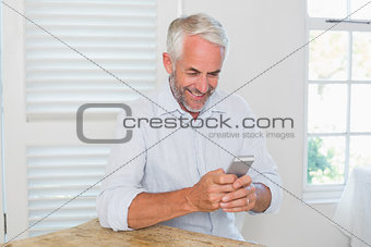 Mature man text messaging at home