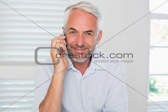 Happy mature man using mobile phone