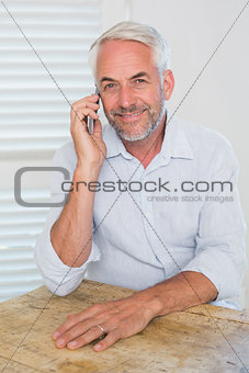 Mature man using mobile phone at home