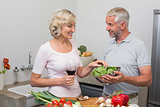 Mature couple preparing food together in kitchen
