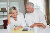 Casual mature couple with home bills and calculator