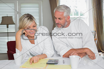 Casual mature couple with home bills and calculator