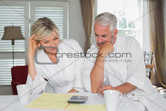 Couple sitting with home bills and calculator