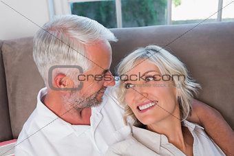 Close-up of happy relaxed mature couple on sofa