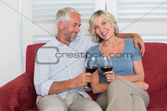Happy relaxed mature couple toasting wine glasses