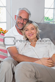 Relaxed mature couple sitting on sofa in living room