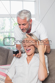 Mature man surprising woman with a wedding ring