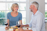 Mature couple with wine glasses having food