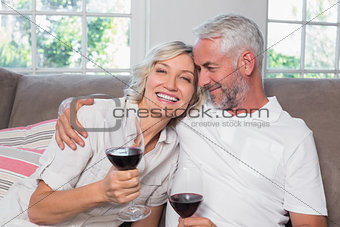 Loving mature couple with wine glasses in living room