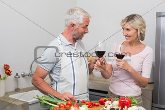 Mature couple with wine glasses in kitchen