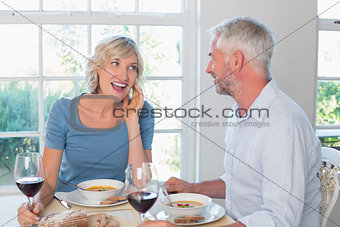 Mature couple with wine glasses having food
