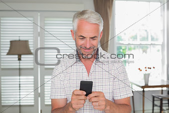 Relaxed mature man text messaging