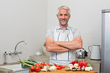 Portrait of a mature man with vegetables in kitchen