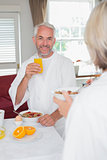 Mature man having breakfast with cropped woman
