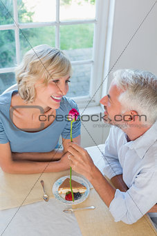 Mature man giving flower to a happy woman