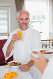 Mature man having breakfast with cropped woman