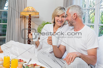 Mature couple having breakfast in bed