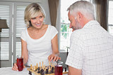 Happy mature couple playing chess
