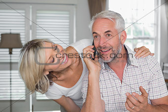 Woman with mature man while he's using mobile phone