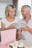 Mature man giving a gift box to happy woman
