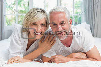 Happy mature couple lying in bed