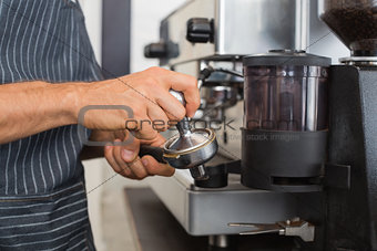 Mid section of a barista prepares espresso in coffees hop